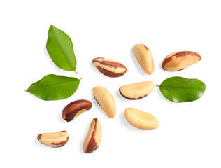 Composition with Brazil nuts and leaves on white background, top view