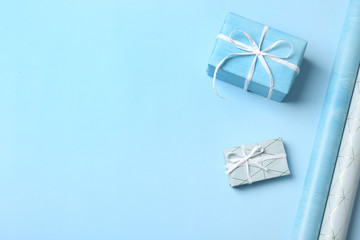 Beautiful gift boxes and wrapping paper rolls for decor on color background. Space for text