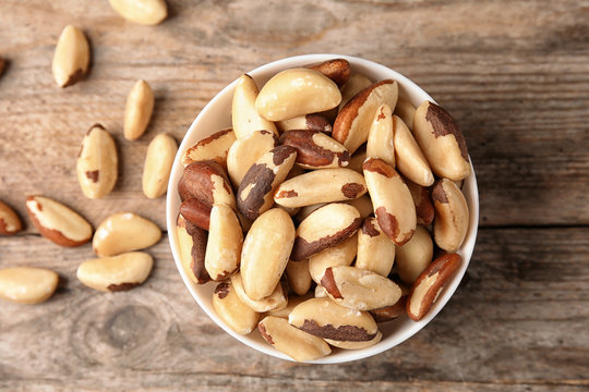 Composition with tasty Brazil nuts on wooden background, top view