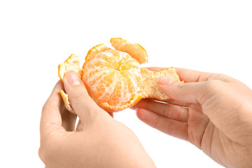 Woman peeling ripe tangerine on white background, closeup