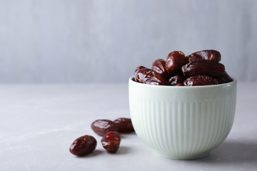 Bowl with sweet dates on table, space for text. Dried fruit as healthy snack
