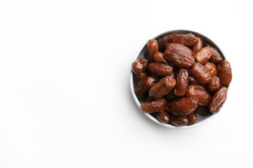 Bowl with sweet dried date fruits on white background, top view. Space for text