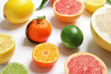 Different juicy citrus fruits on white background