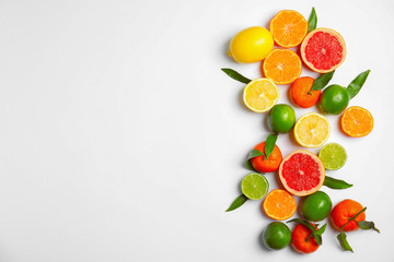 Different citrus fruits on white background, top view. Space for text