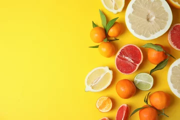 Foto auf Acrylglas Früchte Verschiedene Zitrusfrüchte auf farbigem Hintergrund, Draufsicht. Platz für Text