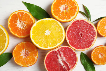Different citrus fruits on wooden background, top view