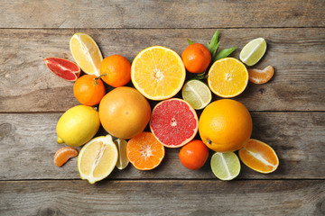 Obraz na płótnie Canvas Different citrus fruits on wooden background, top view