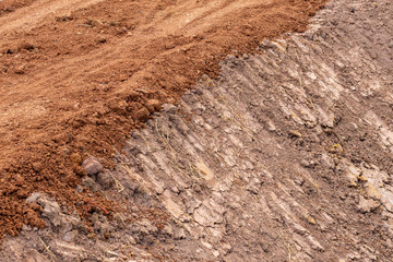 Red gravel soil on the dirt road.