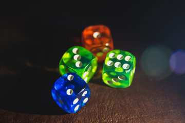 Multi color dice shinning in the dark by soft light