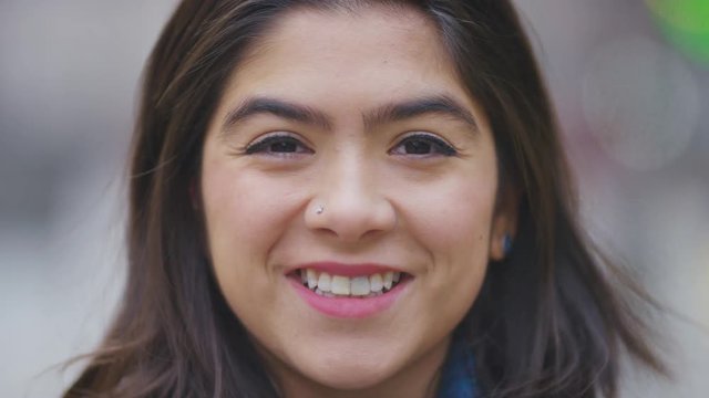 Portrait of happy young hispanic female smiling to camera 