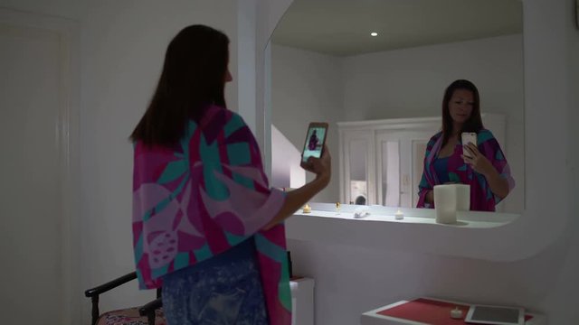 Woman makes selfi in front of a mirror