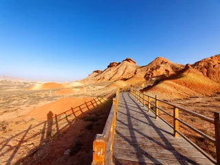 Deurstickers Zhangye Danxia Walking paths around sandstone rock formation at Zhangye National Geological Park. Zhangye Danxia National Geopark, Gansu, China. Colorful landscape of rainbow mountains with blue sky background.