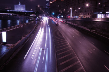 Fototapeta na wymiar night traffic of cars leaves light streaks purple color