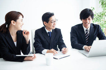 笑顔で仕事をこなす三人のビジネスチーム