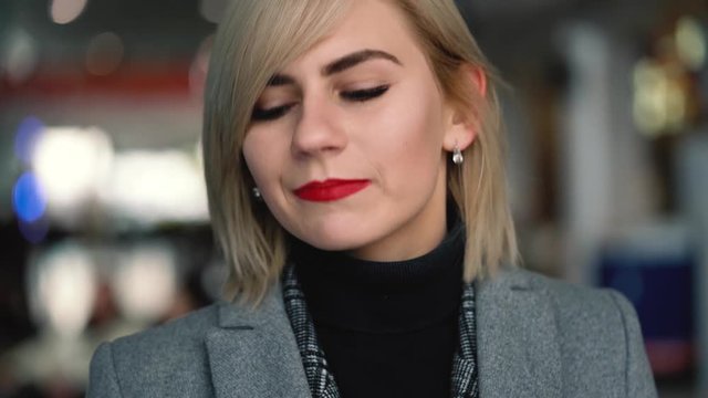 Portrait of a beautiful blonde girl with red lips. Slow motion