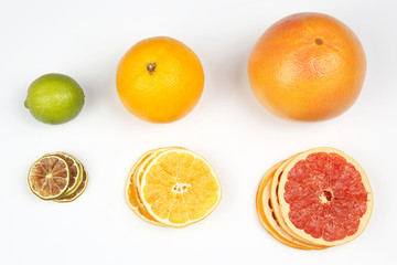 fresh orange, lemon and grapefruit and pieces of dried fruit on white background
