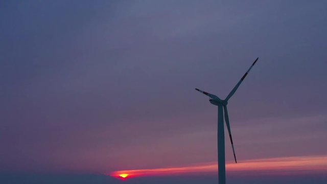 Silhouette of energy producing wind turbines at sunset, Poland. Filmed at various speeds: normal and accelerated