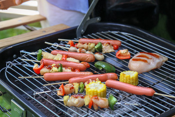 Chicken grilled in the skewer, sausage, corn and sweet chilli barbecue party in the garden