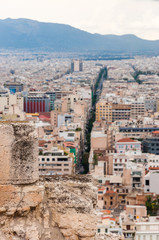Panoramic cityscape view on Greece capital Athens city from Acropolis hill. View through ancient ruined stones on straight street