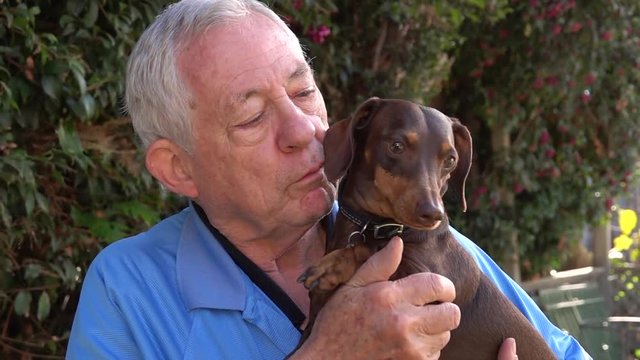 Senior man holding and cuddling his dog
