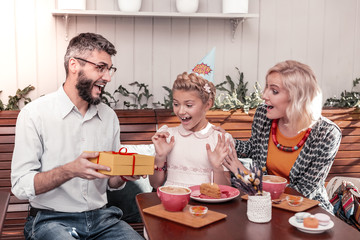 Joyful excited girl looking at the gift box