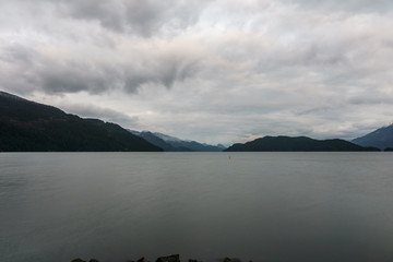 morning on beautiful Harrison lake with mountain background and cloudy sky.