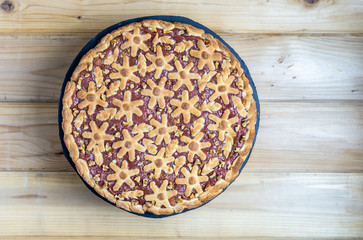 cake with berries and rhubarb on a wooden table.