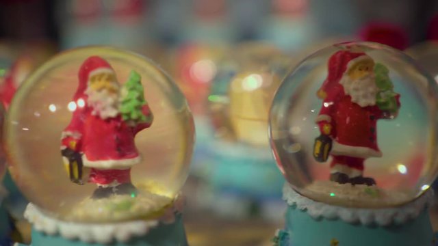 Santa Claus Christmas house in charming Scandinavian village - toys overview - snow globe with Santa clause mini figure inside - close up macro shot with blurred background