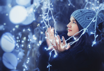 Portrait of a girl holding a Christmas decoration outside.