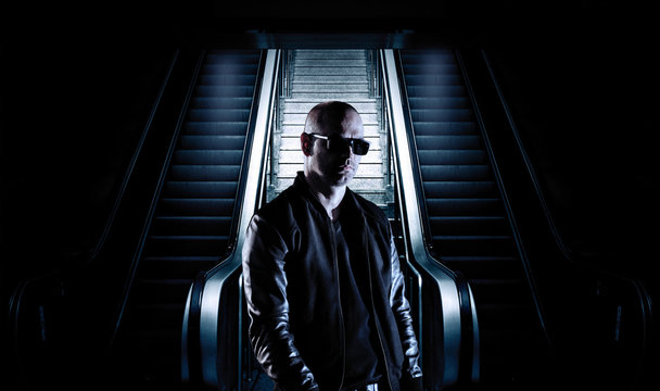 Man standing in front of elevator stairs wearing a black jacket.
