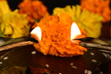 Diyas ( indian candles with flame) with marigold flowers