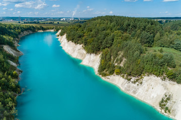 An old gypsum quarry filled with blue and pure water. Aerial view, from top to bottom