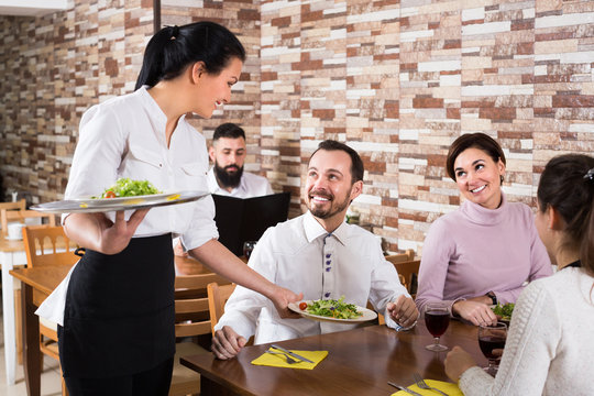 Woman waitress serving meal for cafe guests