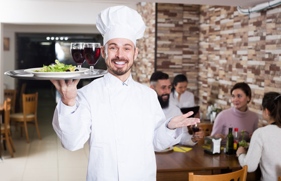 Happy male chef demonstrating country restaurant