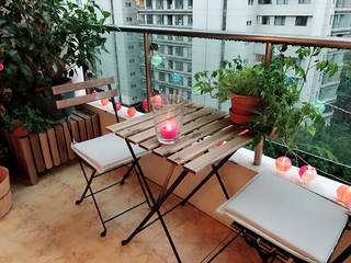 Lovely decoration for terrace with plants, table, chairs and candle