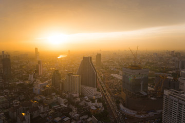 Fototapeta na wymiar Aerial view of modern office and condominium building in Bangkok with orange sunset.