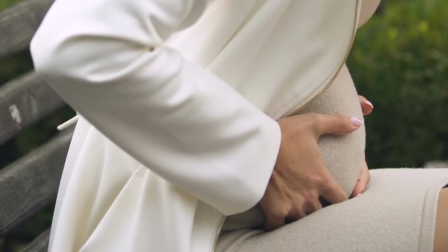 Pregnant female with big belly feeling strong contractions, soon delivery
