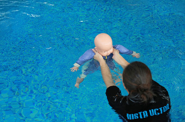 Instructor training dummy drowning baby doll in the pool.