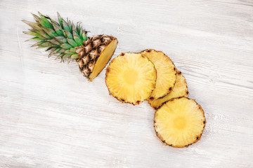 Sliced pineapple on white wooden table. Top view.