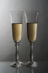 Two glasses with champagne on a gray background