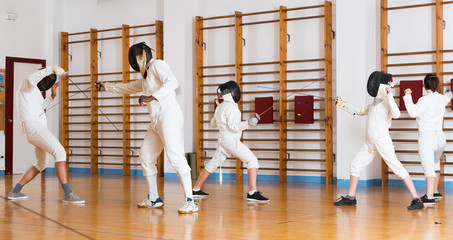 Young fencers training with coach