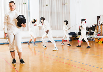 Woman in fencing uniform in gym