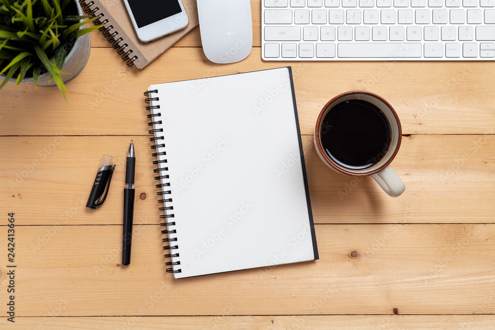 Wall mural top view empty notebook and coffee with computer on wooden table ,top view