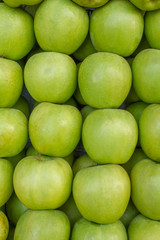 Fresh, clean, green apples lie in even rows. natural surface texture