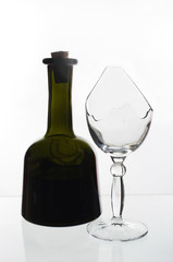 Bottle of wine and a broken glass on a light background