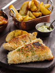 Fried fish with tomato-olive sauce and potatoes.