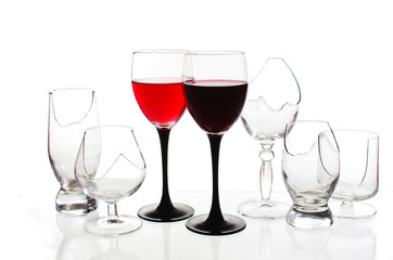 Two glasses of red wine on the background of broken glasses on a light background