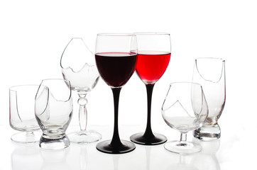 Two glasses of red wine on the background of broken glasses on a light background