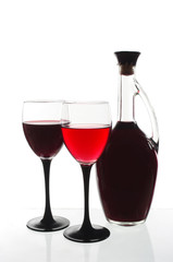 Two glasses of wine and a bottle on a light background