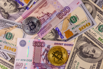 Bitcoin coins on the american and russian banknotes